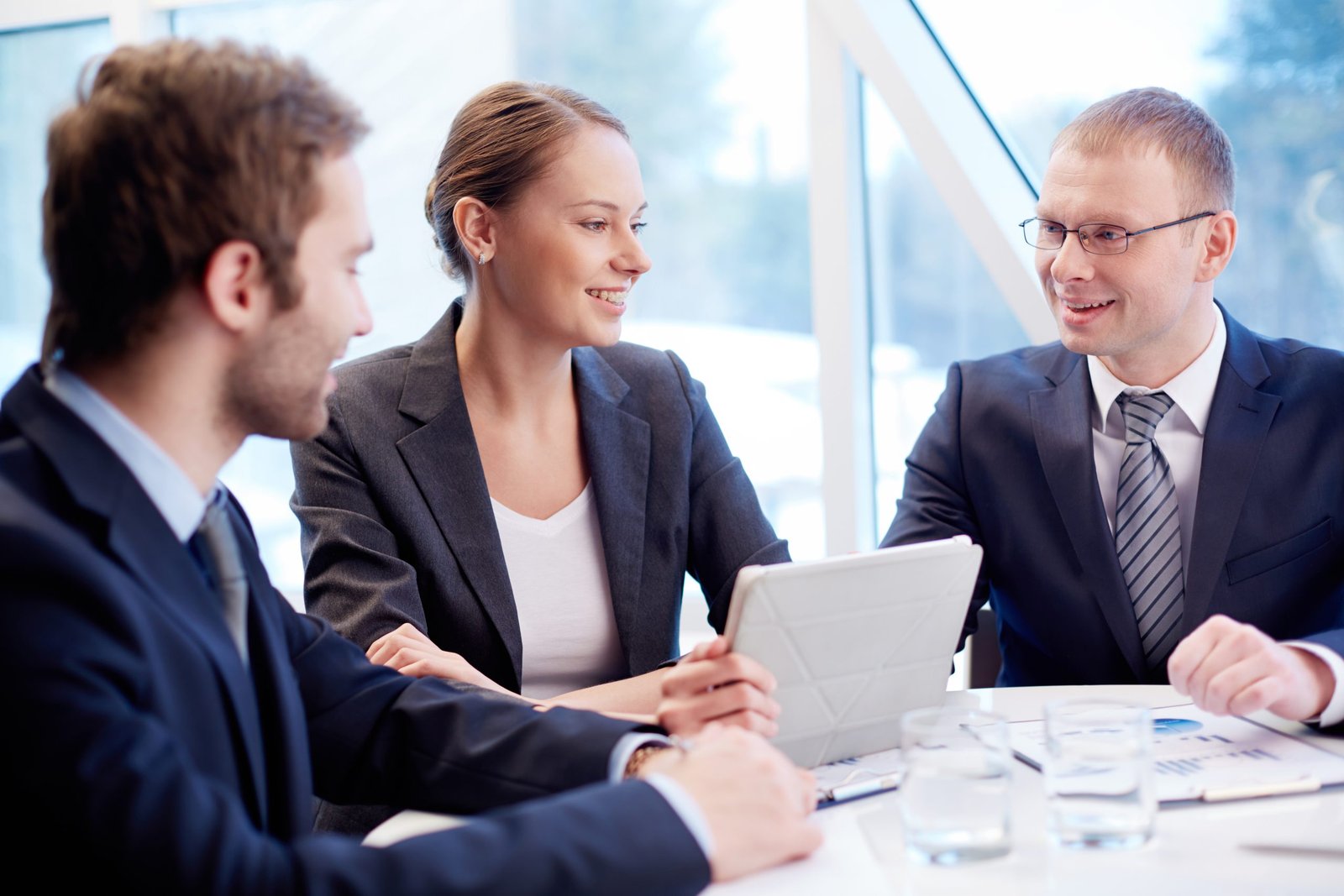 Discussion Three business people smiling and planning work at a meeting table