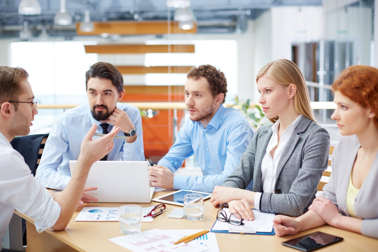 Talk-in five business people sat at a table having a serious team meeting