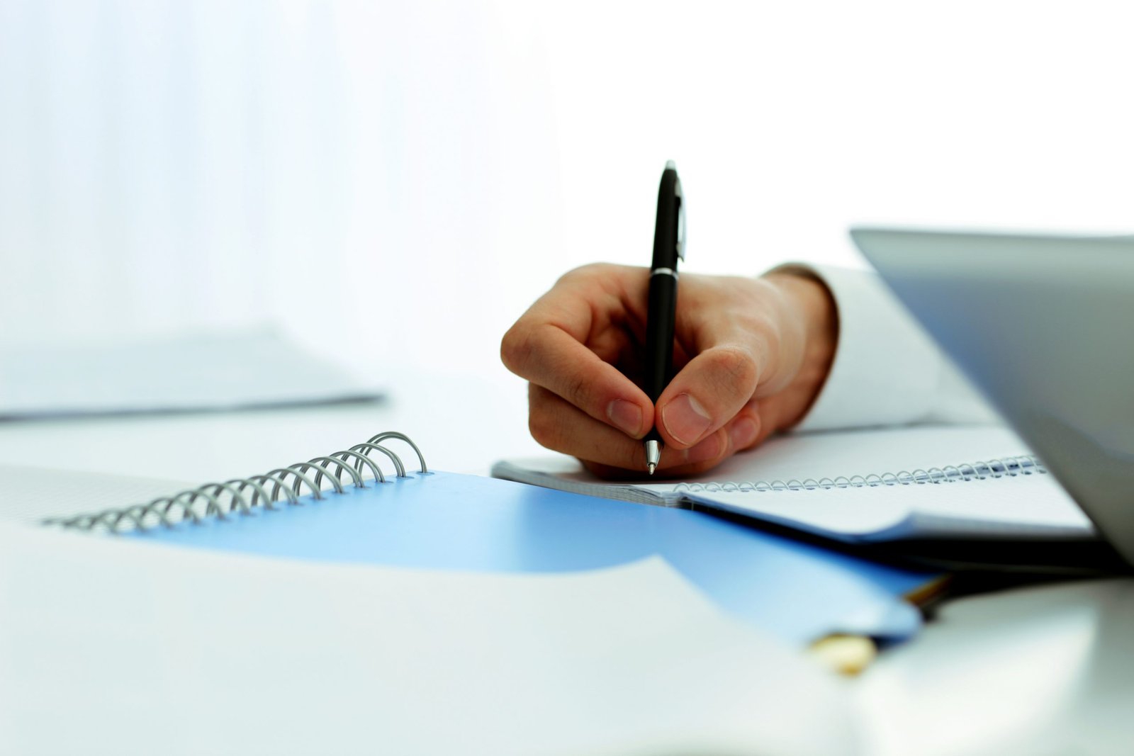 Closeup image of mans hand writing in notebook Closeup image of mans hand writing in notebook